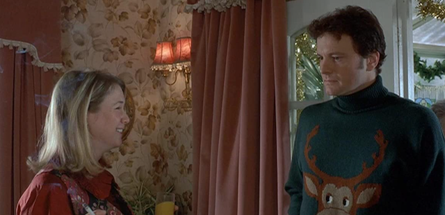 A woman and man stand next to one another wearing ugly Christmas sweaters