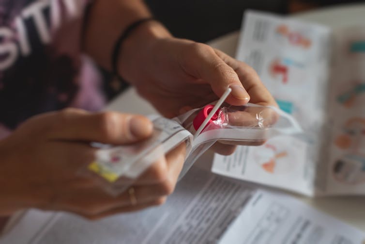 Person opens a rapid antigen testing kit.