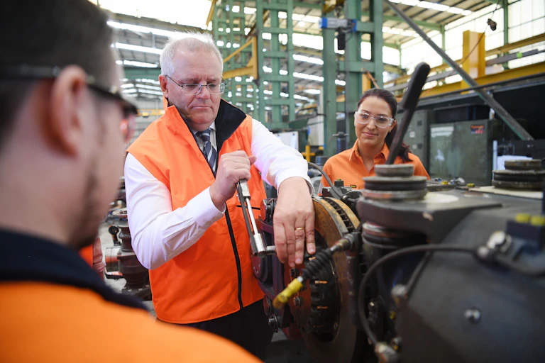 man in hi-vis vest tightening a part on machinery