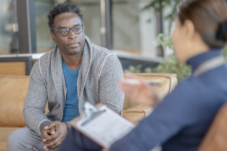 A man in session with a female therapist.