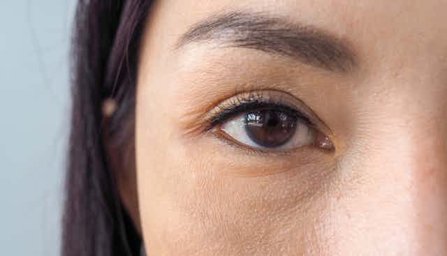 Close-up of a woman's brown eye gazing directly into the camera