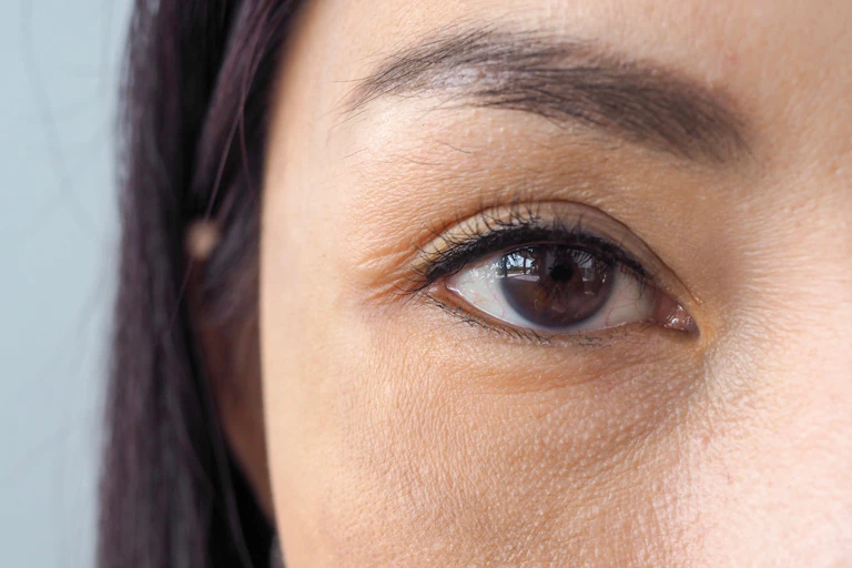 Close-up of a woman's brown eye gazing directly into the camera
