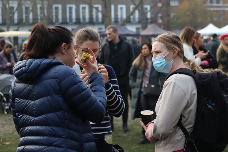 People outside socialising at a Christmas market