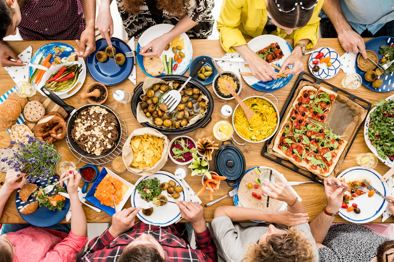 A group of people sit at a table sharing a plant based meal