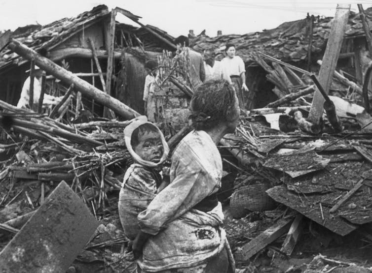An elderly woman and her grandchild wander among the debris of their wrecked home in the aftermath of an air raid by U.S. planes over Pyongyang, the Communist capital of North Korea. (Photo by Keystone/Getty Images)