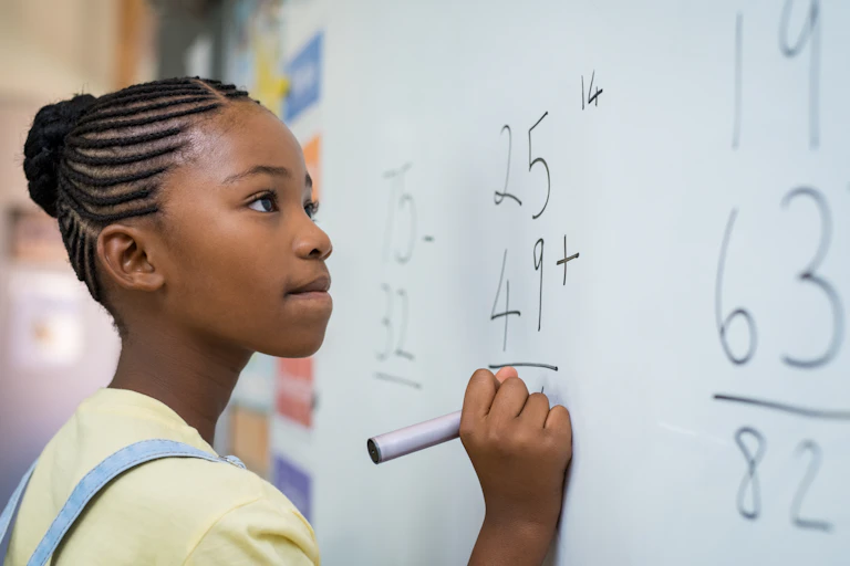 Girl doing maths on whiteboard