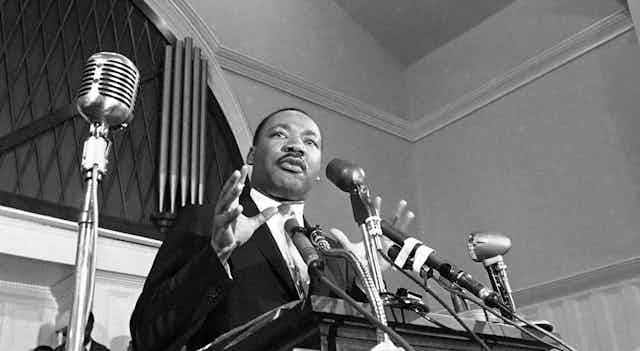 Martin Luther King Jr. speaks at a lectern in the 1960s.