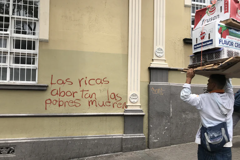 Graffiti covers a building that reads 'the rich abort, the poor die.'