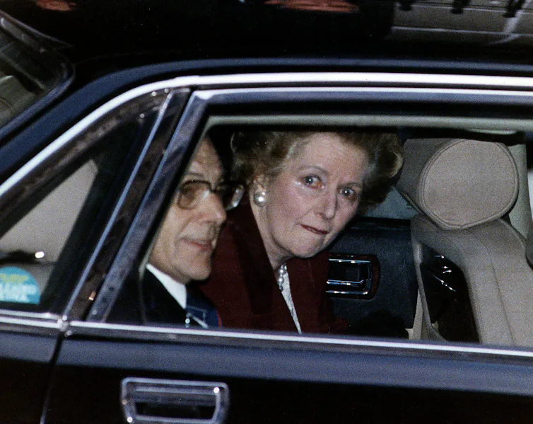Margaret Thatcher looking tearful in the back of a car.