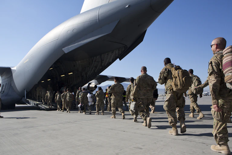Soldiers walk into a cargo plane.