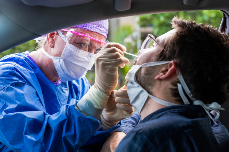 A man being swabbed for COVID at a drive through testing centre