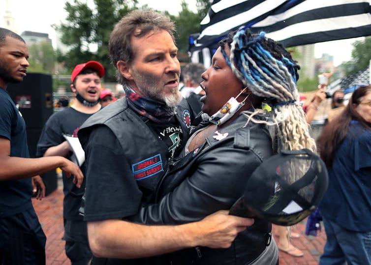 A woman wraps her arms around a man