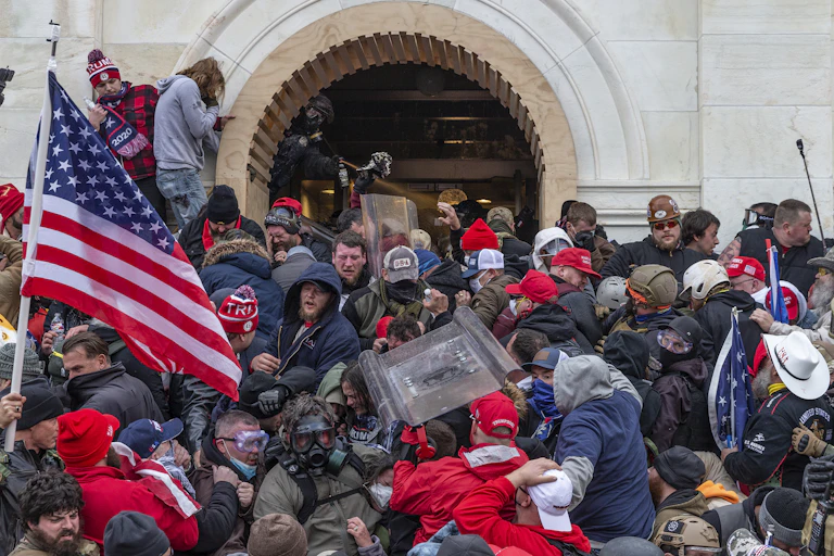A large crowd of protesters being tear gassed by police during the US Capitol attack.