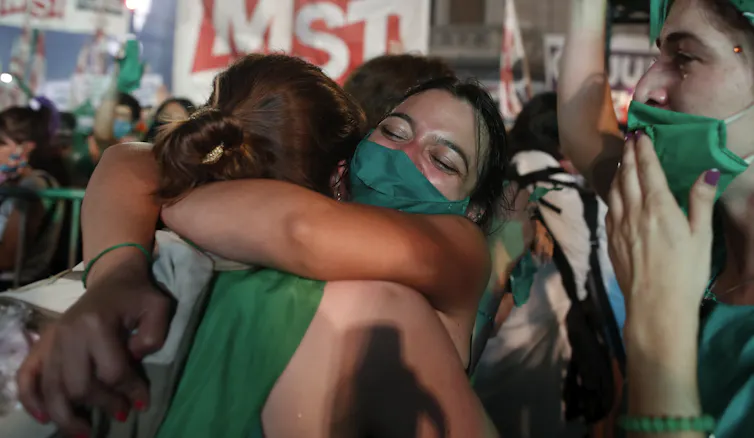 Woman wearing green hug and cry