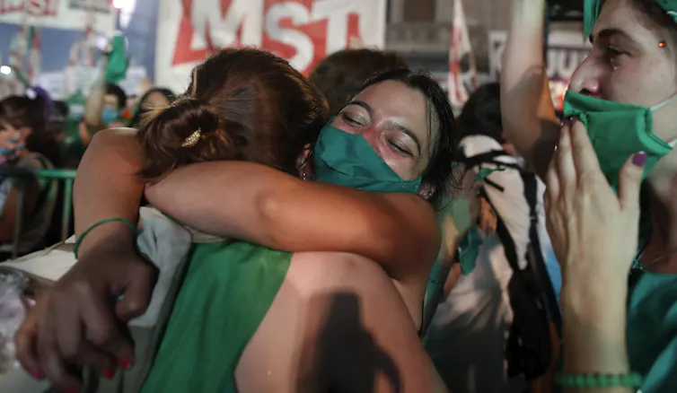 Woman wearing green hug and cry