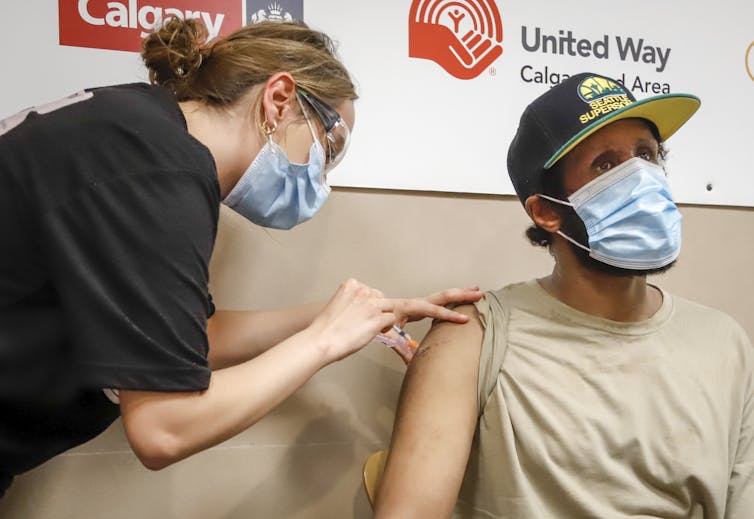 Nurse giving a man a vaccination shot in the arm