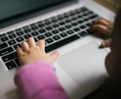 A child's hands on a keyboard.
