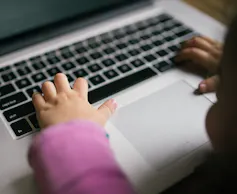 A child's hands on a keyboard.