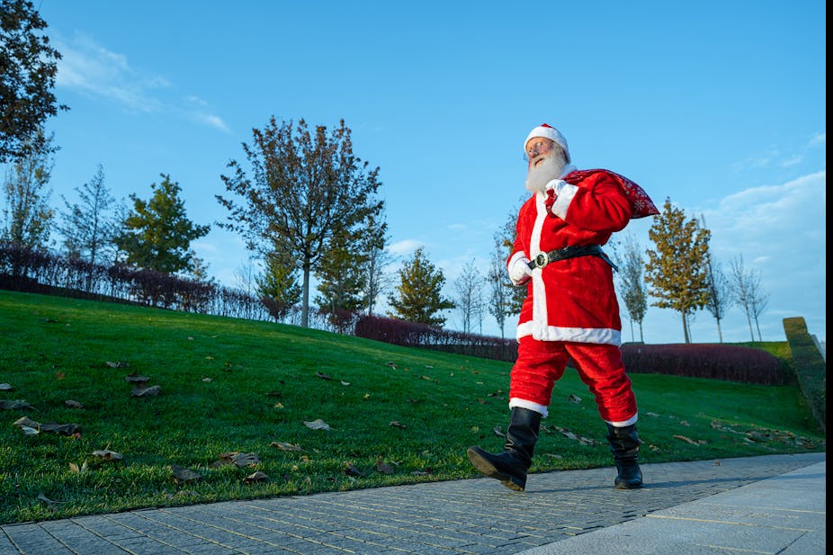 Santa Claus out for a walk in the park.