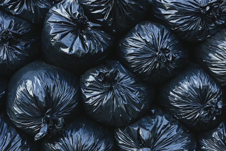 Stack of tightly filled black garbage bags.