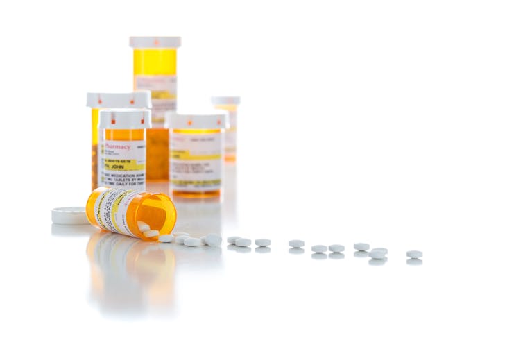 Prescription bottles and white tablets on a white background