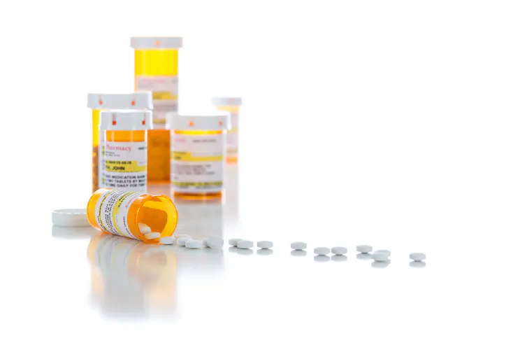 Prescription bottles and white tablets on a white background