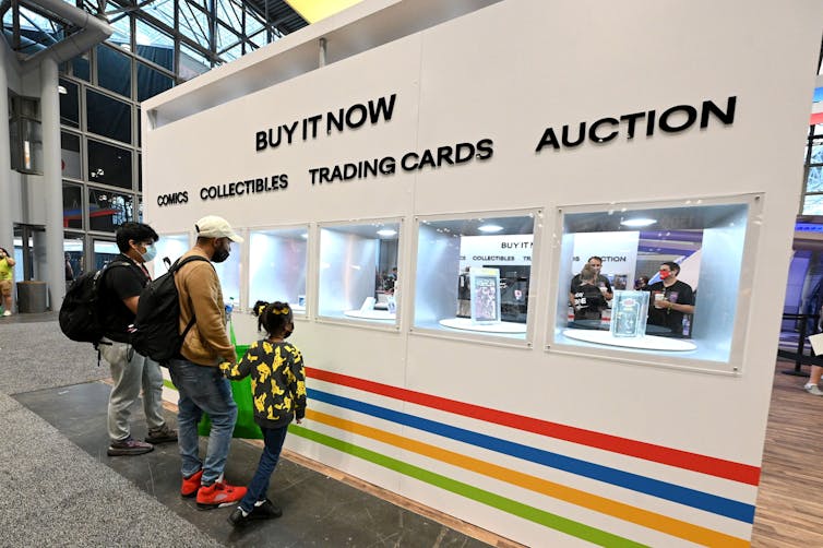 A family stands at a trading card booth.