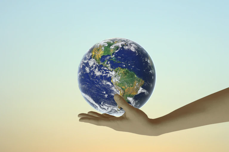 Earth balanced in the palm of an outstretched hand