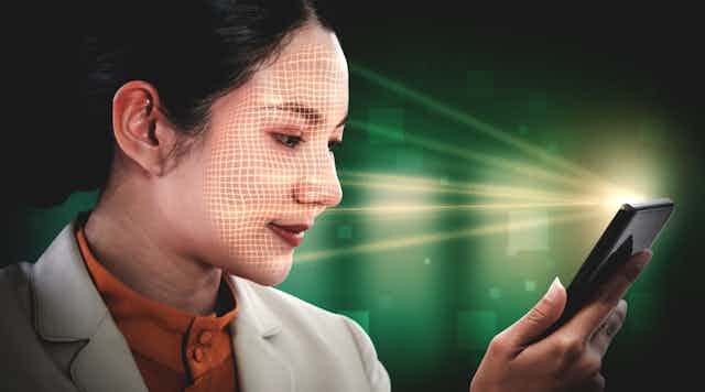 a woman holding a cell phone that is scanning her face