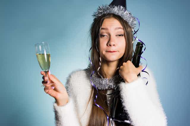 Drunk woman, holding up a glass of champagne