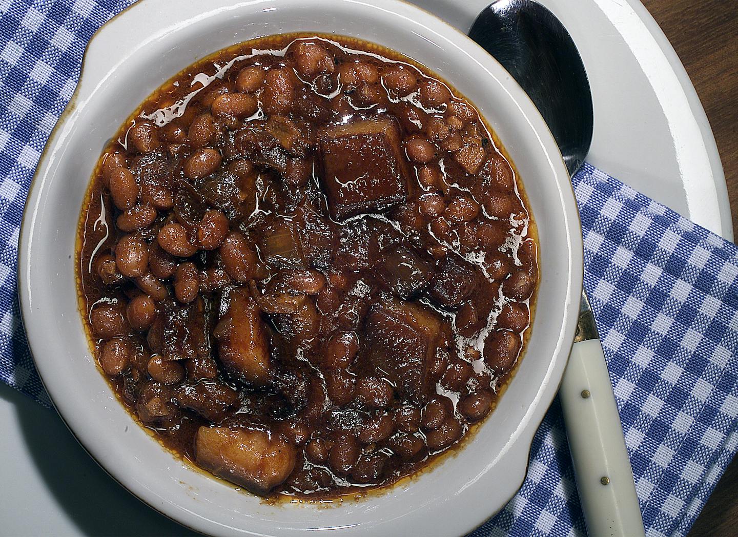 A bowl of gooey brown Boston baked beans