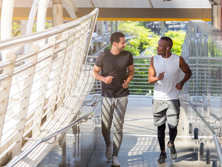 Two young men walking in exercise clothes