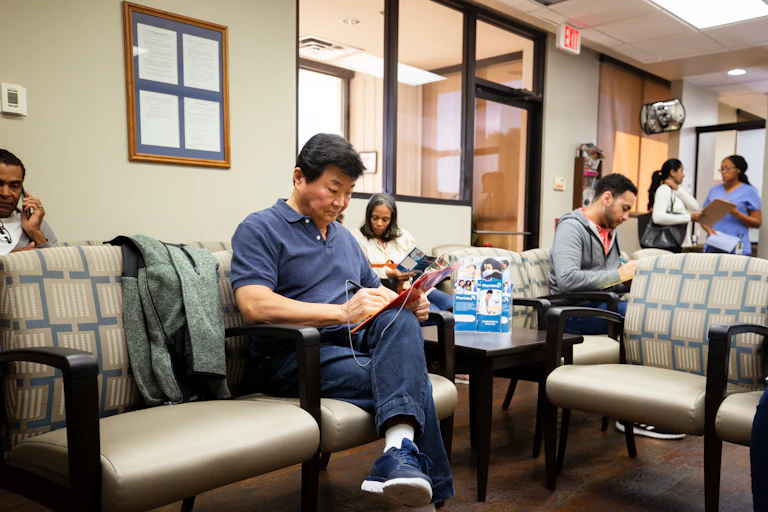 Multiethnic group of people sitting in a clinic waiting room.