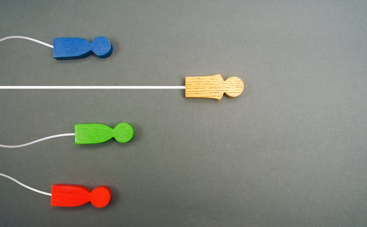 Symbolic image showing one real human figurine ahead of the rest. inch class=