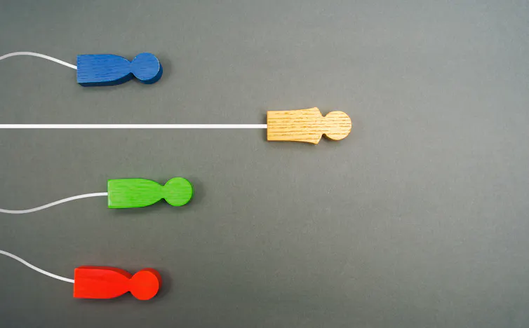 Symbolic image showing one human figurine ahead of the rest.