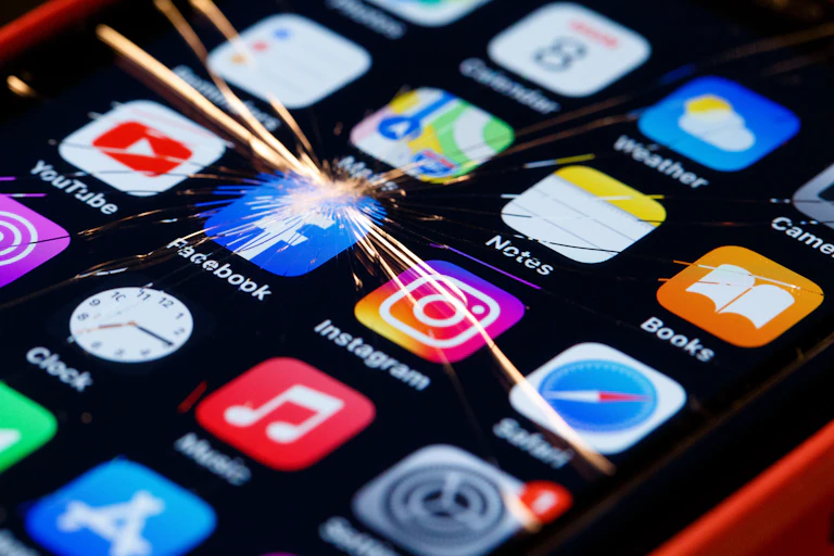 Cracked phone screen over the facebook icon.