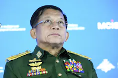 A man in an military uniform looks up.