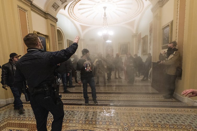 People are seen staggering amid smoke in a hallway.