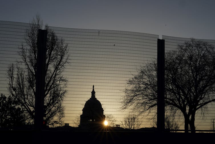 The sun rises behind the U.S. Capitol building.