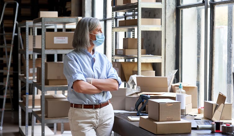 A woman looks over boxes she is packing