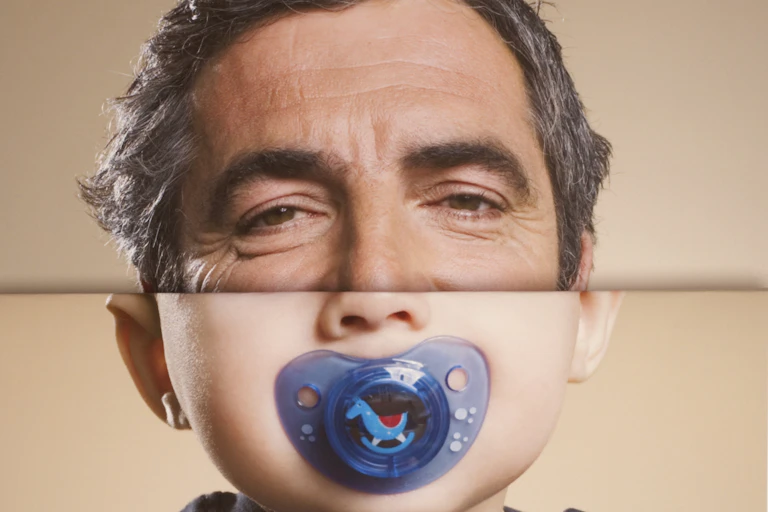 Top half of face a man, bottom half a baby with pacifier.
