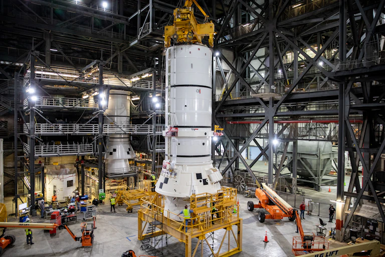 Rocket boosters being constructed by Nasa with workmen at their base.