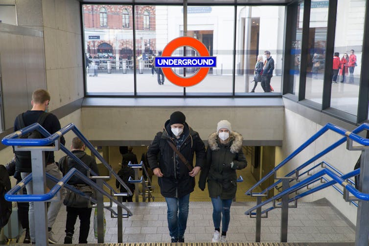 Masked passengers coming out of a London tube station