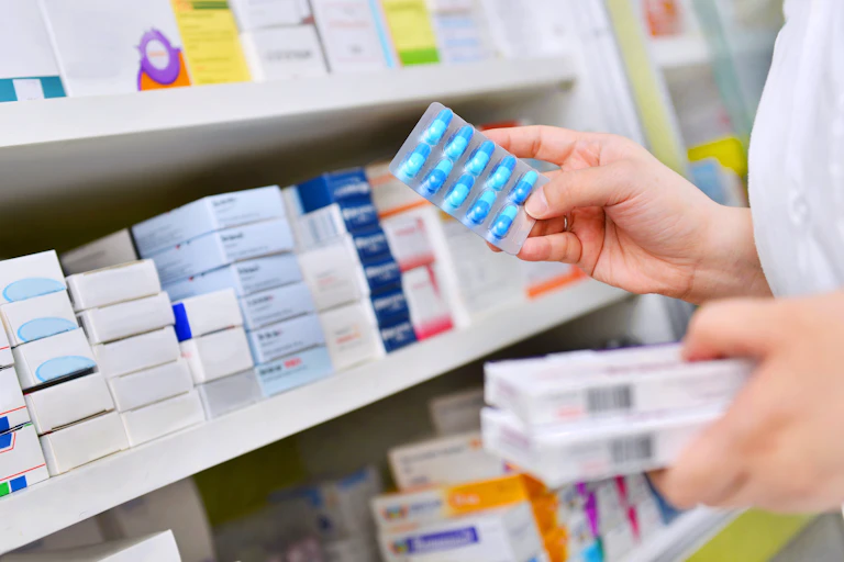 A pharmacist selecting antibiotics rom a shelf