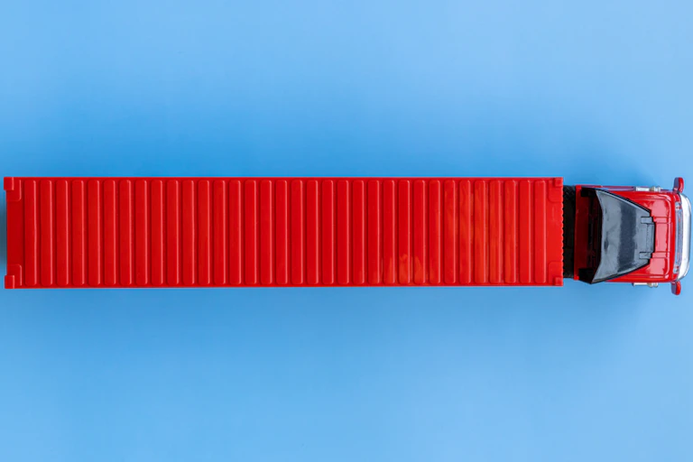A big red lorry against a blue background, seen from above.