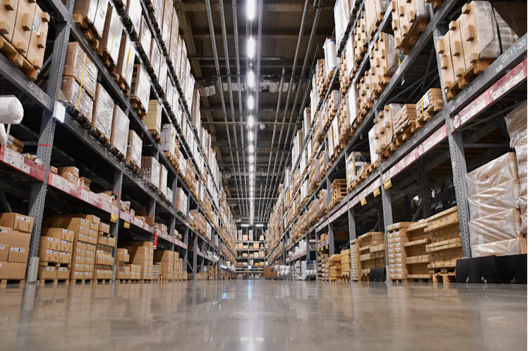 An aisle in a warehouse with shelves stacked with boxes