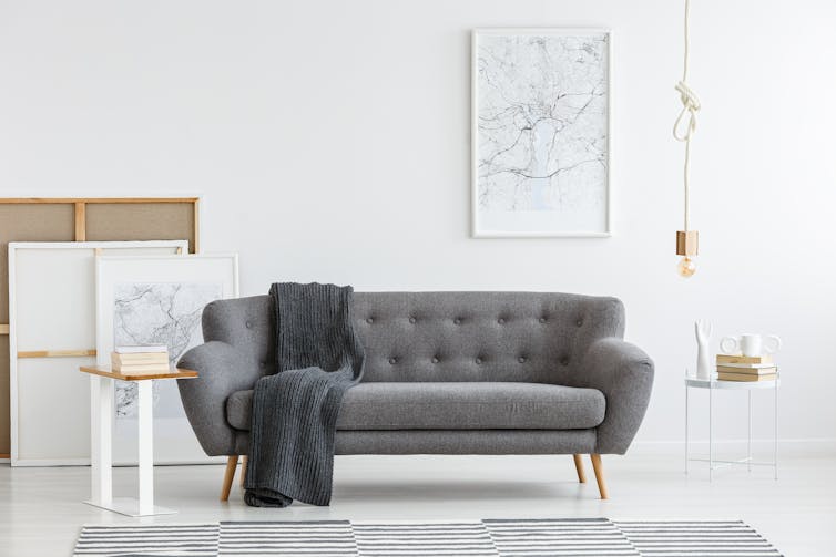 Scandi living room interior with grey, big sofa in the center and modern picture on the wall