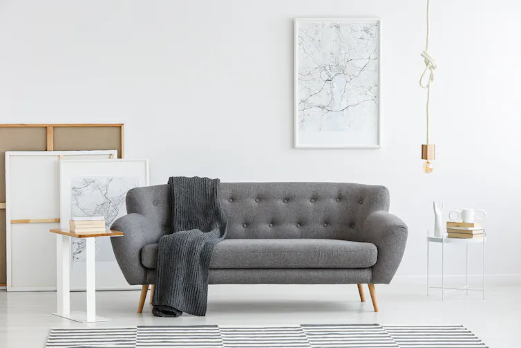 Scandi living room interior with grey, big sofa in the center and modern picture on the wall