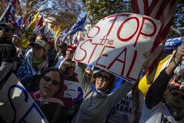 A group of Donald Trump's supporters, one carrying a large banner reading 'Stop the Steal'.
