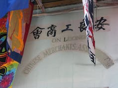 Faded letters on a building spell 'On Leong Chinese Merchants Association'